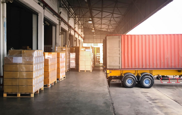 Truck delivering shipment at warehouse loading dock in New Hampshire